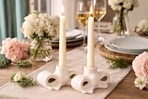 Lifestyle image (created from ChatGPT) of the My Texas House Bow Stoneware Candle Holder set on dining table