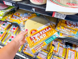 hand pulling out a package of tortillaland tortillas on walmart shelf