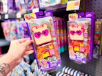 hand holding polly pocket cutie bear playset next to another on walmart hanger