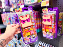 hand holding polly pocket cutie bear playset next to another on walmart hanger