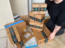 Someone picking up Amazon prime boxes on the porch