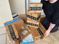 Someone picking up Amazon prime boxes on the porch