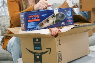 Corded car vacuum being held next to amazon box