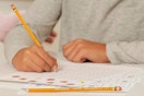 child holding a pencil at desk