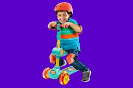 Toddler using the fold down seat on the CoComelon scooter