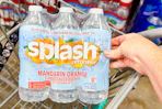 hand touching a pack of splash water in cart