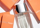 a bottle of perfume next to orange boxes