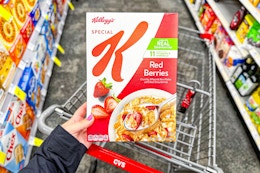 person holding a box of special k cereal over a cvs cart