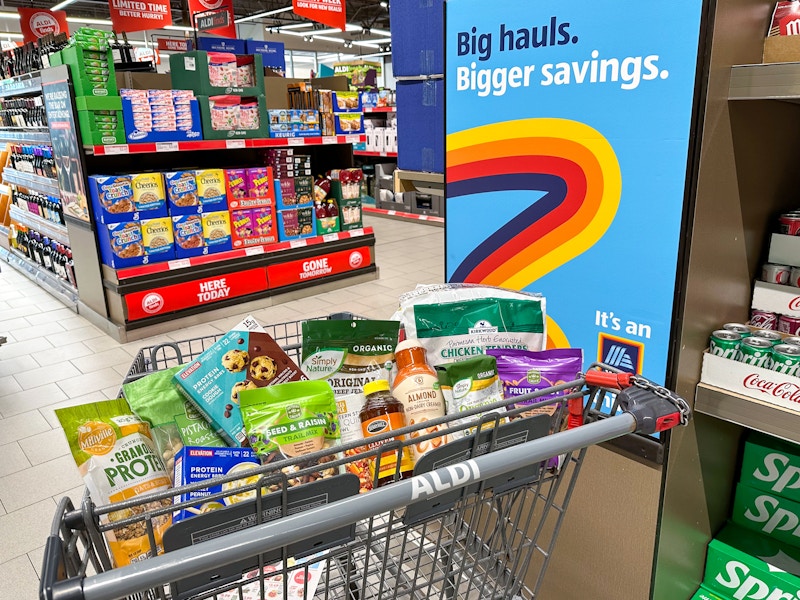 A cart full of groceries at Aldi parked next to a sign