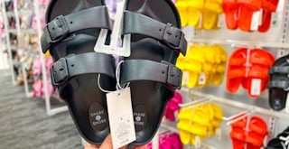 a hand holding black sandals at target
