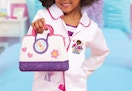 child holding a Doc McStuffins doctor bag and wearing a doctor jacket
