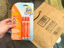 Someone holding a three pack of Tide to go pens next to an Amazon envelope