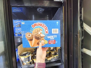 hand holding a box of 16 nestle drumsticks