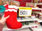hand holding a stocking next to a 50% off Clearance sign