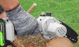 a person using a chainsaw on a log