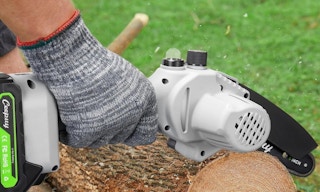 a person using a chainsaw on a log
