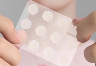woman holding acne patches