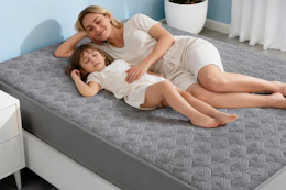 family sleeping on top of mattress protector