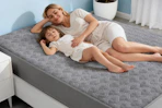 family sleeping on top of mattress protector