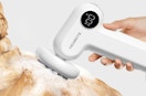an electric pet brush shampooing a dog