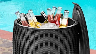 patio table next to a pool with ice and drinks inside