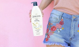person holding bottle of jergens skin firming body lotion