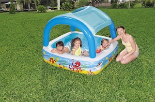 kids playing in an inflatable pool with a canopy