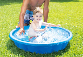 child playing in a blue kiddie pool