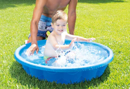 child playing in a blue kiddie pool