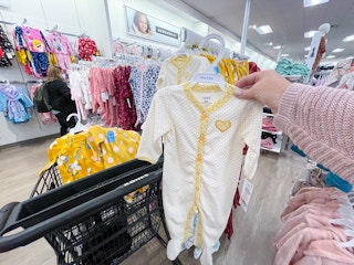 someone holding up carters sleep & plays