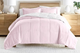 Lifestyle image of the blush/white reversible comforter set from Noble Linens