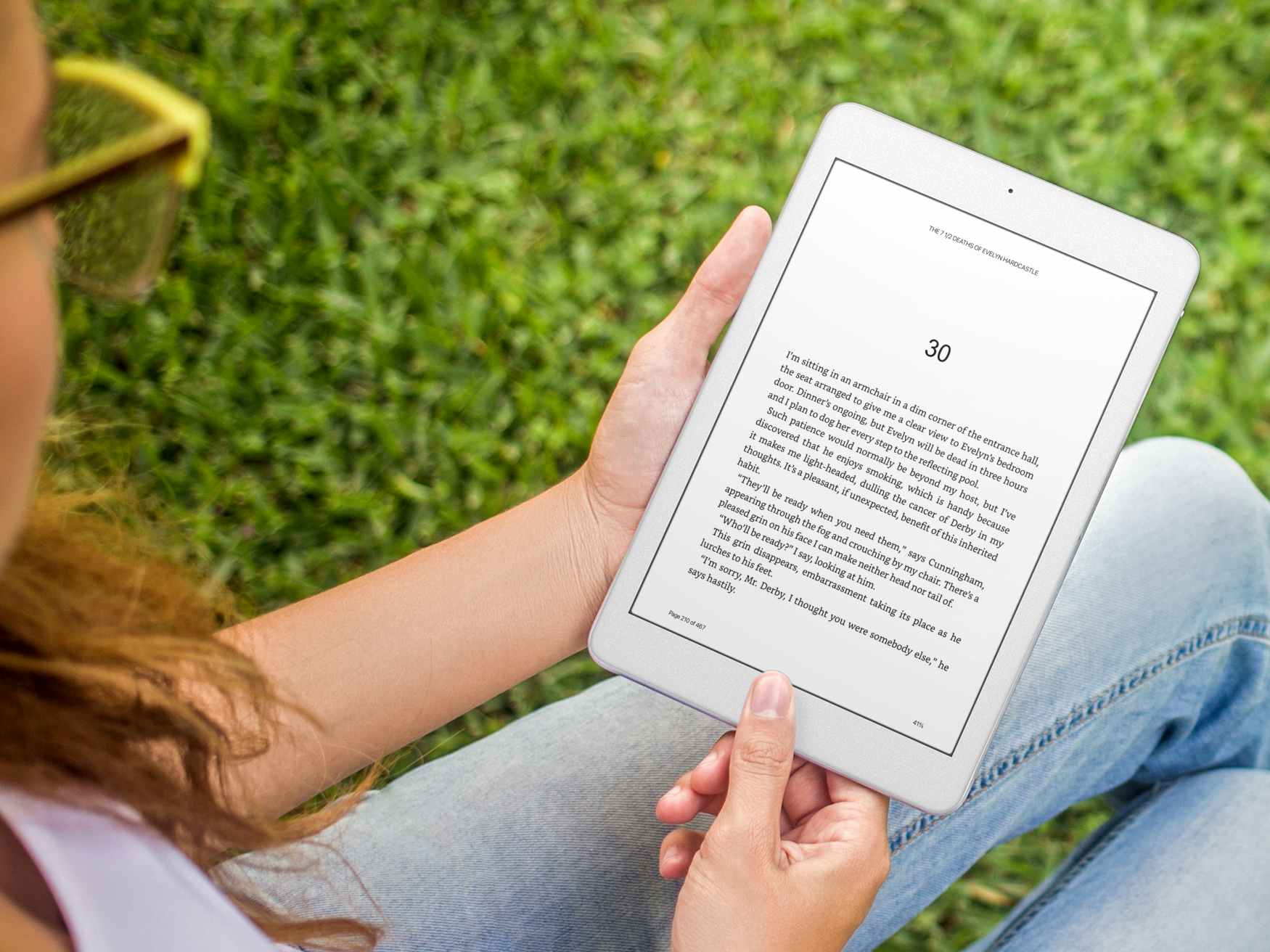 person outside reading an ebook in the amazon kindle app on an ipad