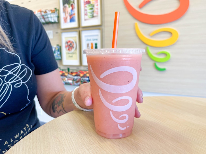 woman holding smoothie on table