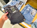 hand grabbing a pair of art class kids shorts off a table at target