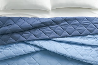 Lifestyle image of a blue king Better Homes & Gardens King Comforter (close up)