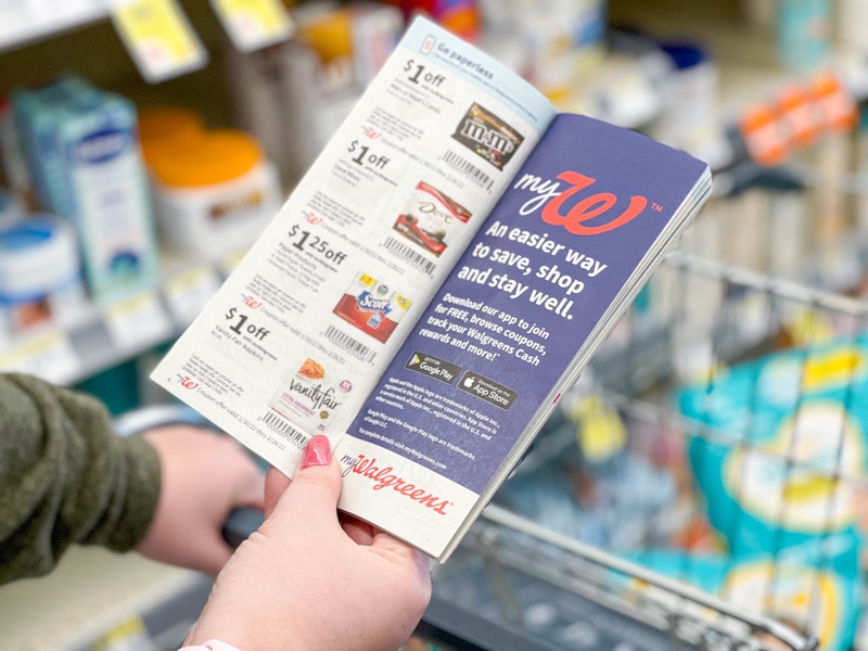 woman looking at walgreens coupon booklet