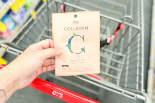 person holding a rael beauty sheet mask over a cart