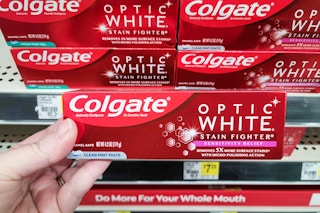 hand holding a box of colgate optic white toothpaste