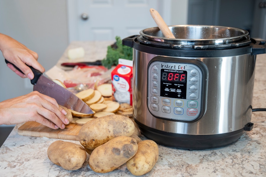 person cutting potatoes near an Instant Pot