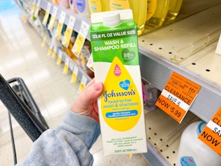 person holding a johnsons baby shampoo by a $5.99 clearance sign