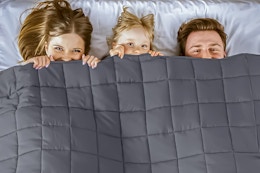 Lifestyle image of three people peeking out from a  Teler Weighted Queen Blanket