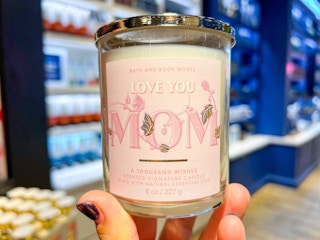 hand holding up a single wick candle in store at bath and body works