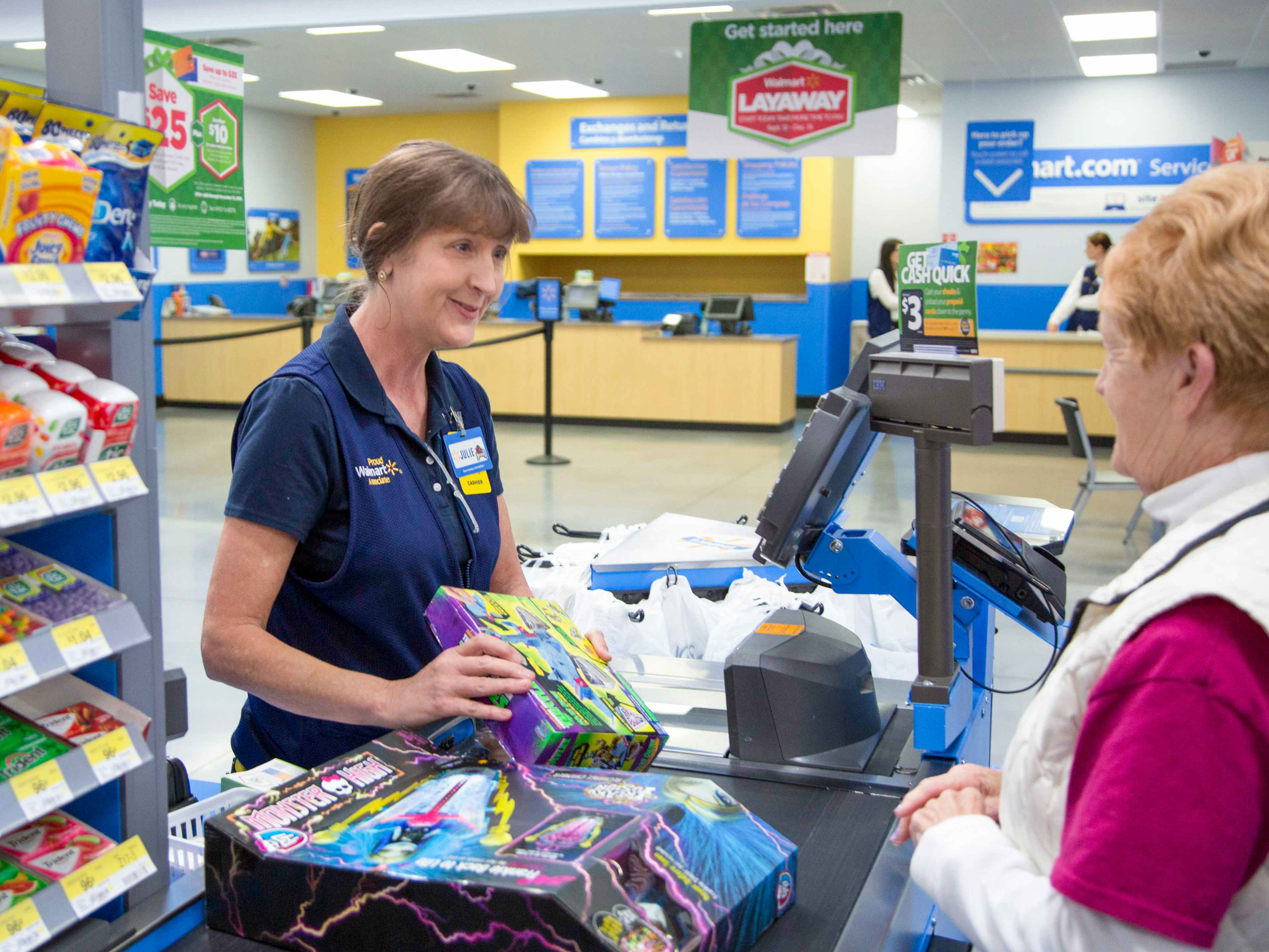 A Walmart employee scanning items for a customer at the checkout counter.