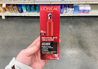 hand holding l'oreal revitalift triple power eye cream