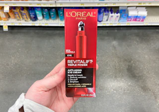 hand holding l'oreal revitalift triple power eye cream