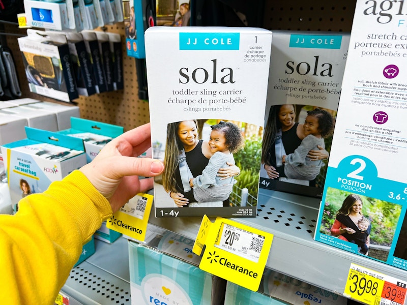 hand holding sola toddler sling carrier on walmart shelf