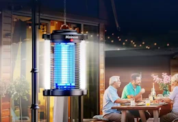 bug zapper hanging on a pole while a family eats dinner outside