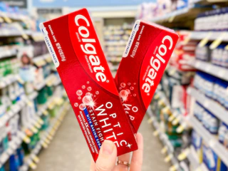 hand holding two boxes of colgate optic toothpaste