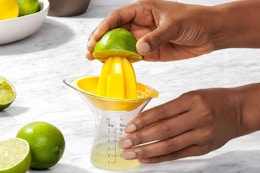 a woman using an oxo juicer