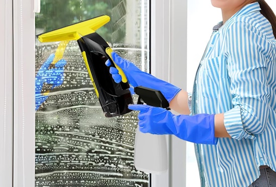 a person using a cordless window squeegee on a window